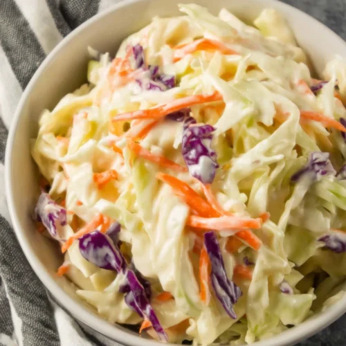 Creamy low calorie coleslaw with cabbage and carrots in a white bowl