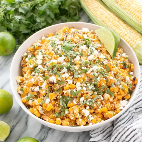 Mexican street corn salad with cotija cheese and cilantro in a white bowl