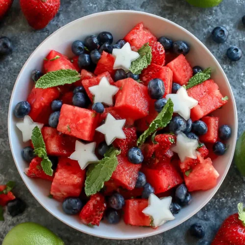 Mojito fruit salad with watermelon, strawberries, blueberries, and mint in a white bowl