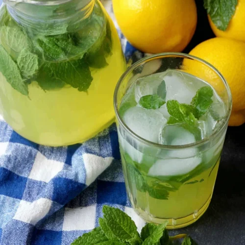 Moroccan mint lemonade with fresh lemons and mint on a checkered cloth