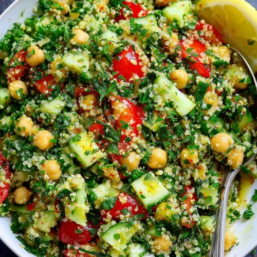 Quinoa chickpea tabbouleh salad with fresh herbs and vegetables in a white bowl