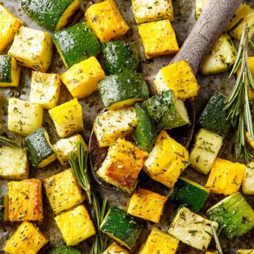 Roasted zucchini and yellow squash with herbs on a baking sheet