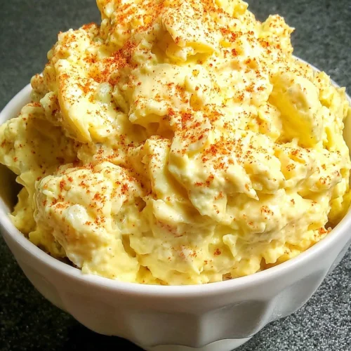 Creamy southern potato salad in a white bowl with paprika garnish