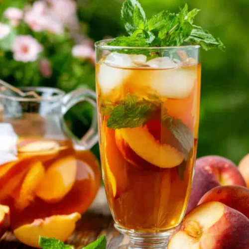 Southern style fresh peach sweet tea with peach slices and mint in a glass