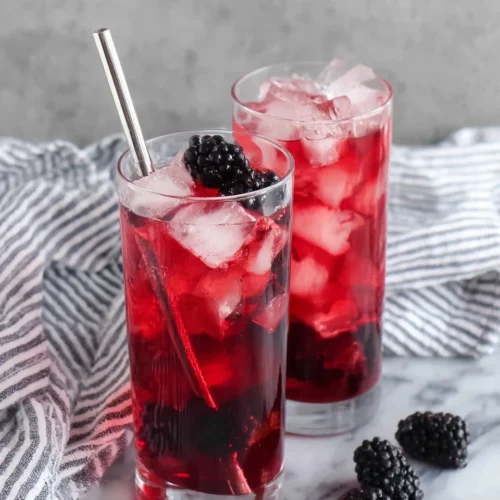 Starbucks Very Berry Hibiscus Refresher in tall glasses with ice and blackberries