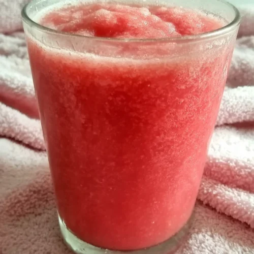 Strawberry smoothie surprise in a glass with condensation, vibrant red color