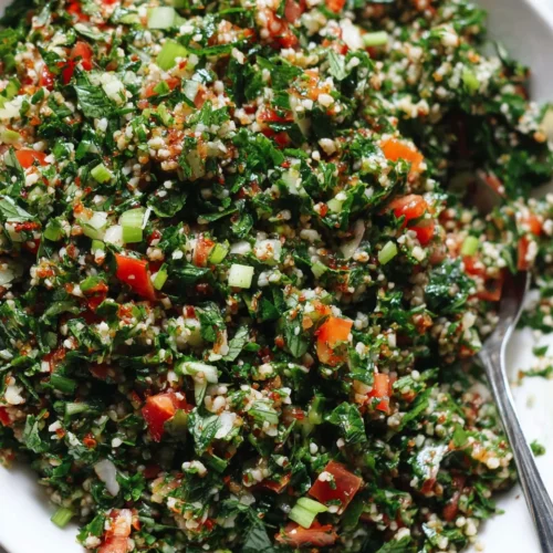 Fresh tabouli salad with parsley, mint, tomatoes, and bulgur wheat in a white bowl
