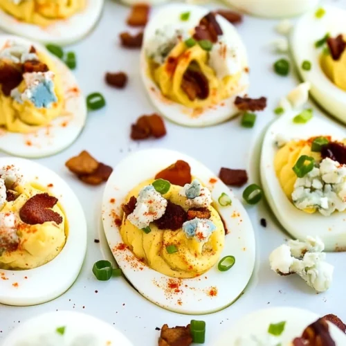 Bacon blue cheese deviled eggs topped with bacon, blue cheese, and chives