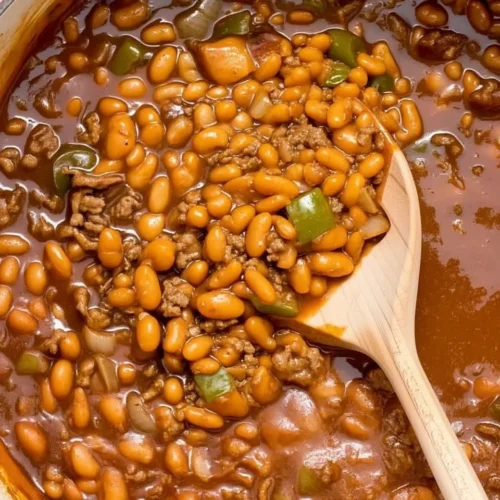 Baked beans with ground beef in a pot with wooden spoon