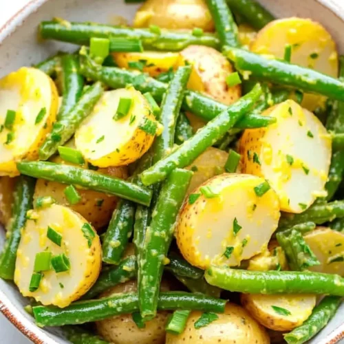 Creamy green bean potato salad with potatoes, green beans, and herbs in a bowl