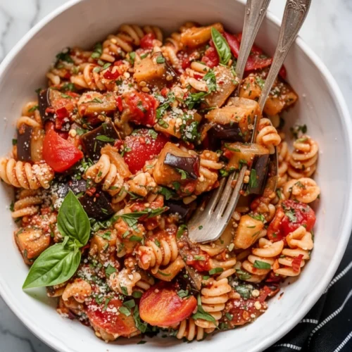 Eggplant and tomato sauce over pasta with fresh basil and cheese