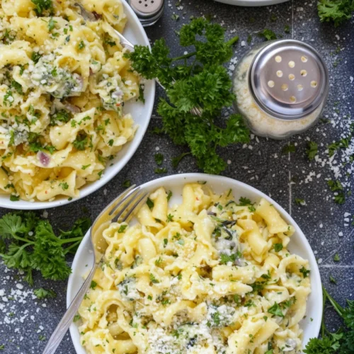 Creamy garlic parmesan summer squash pasta in white bowls with fresh parsley and parmesan.