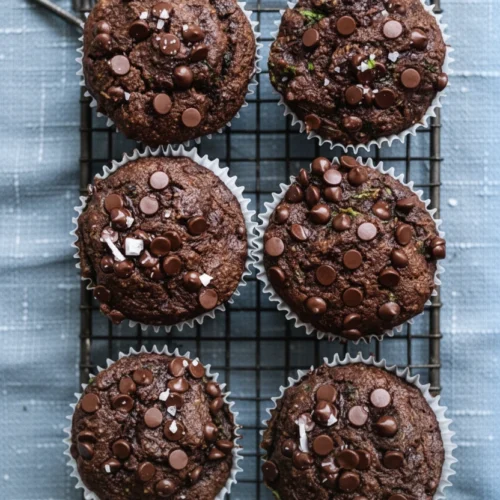 Gluten free chocolate zucchini muffins with chocolate chips on a cooling rack