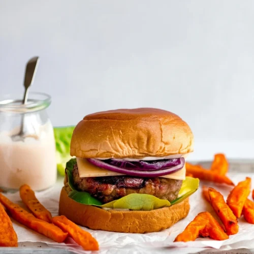 Grilled turkey burger with cheese, lettuce, and sweet potato fries