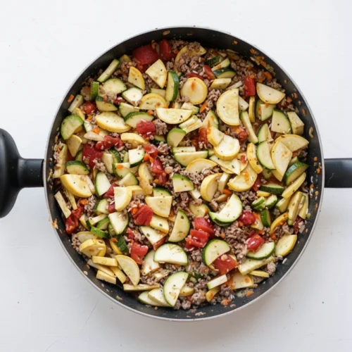 Million dollar zucchini skillet with zucchini, squash, sausage, and rice in a pan