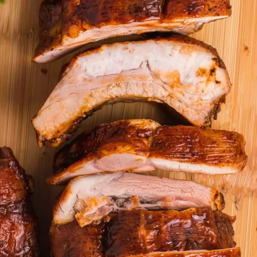 Juicy oven-baked ribs with sticky BBQ glaze on a wooden board