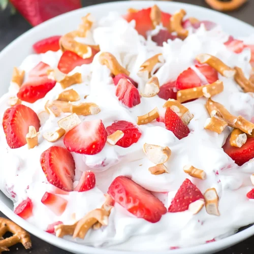 Strawberry pretzel fluff salad with fresh strawberries and crunchy pretzels in a white bowl