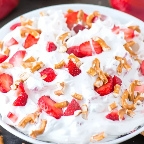 Strawberry pretzel fluff salad with fresh strawberries and crunchy pretzels on top.