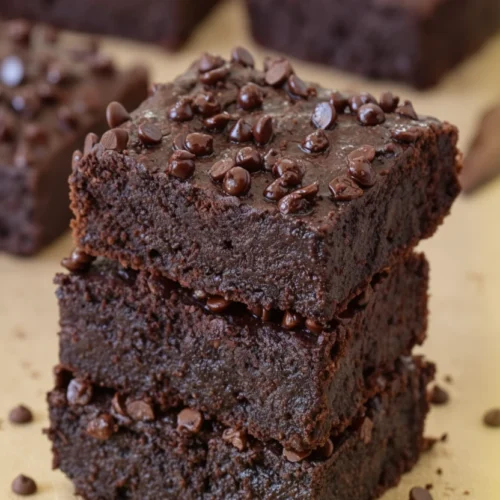 Stack of fudgy vegan zucchini brownies with chocolate chips