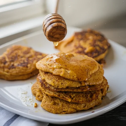 2 Ingredient Pumpkin Pancakes: Delightfully Easy and Healthy 1 2 ingredient pumpkin pancakes with honey drizzle on white plate