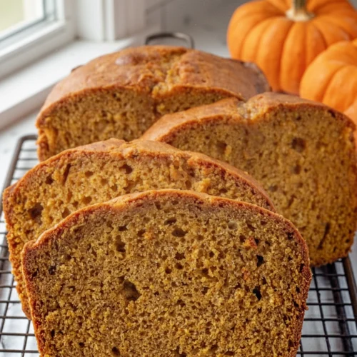 Down East Maine Pumpkin Bread: A Cozy Delight 1 Slices of Down East Maine pumpkin bread on a cooling rack with pumpkins