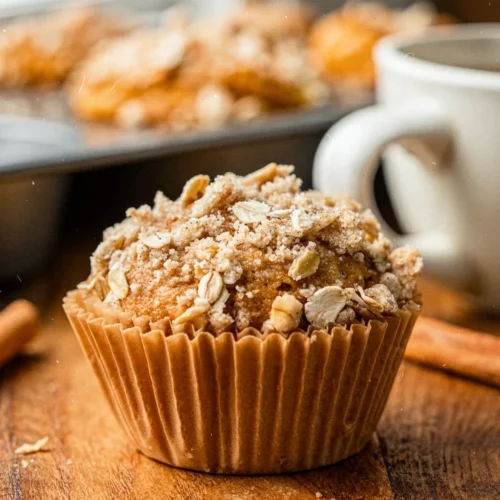 Vegan pumpkin muffin with streusel topping on wooden table